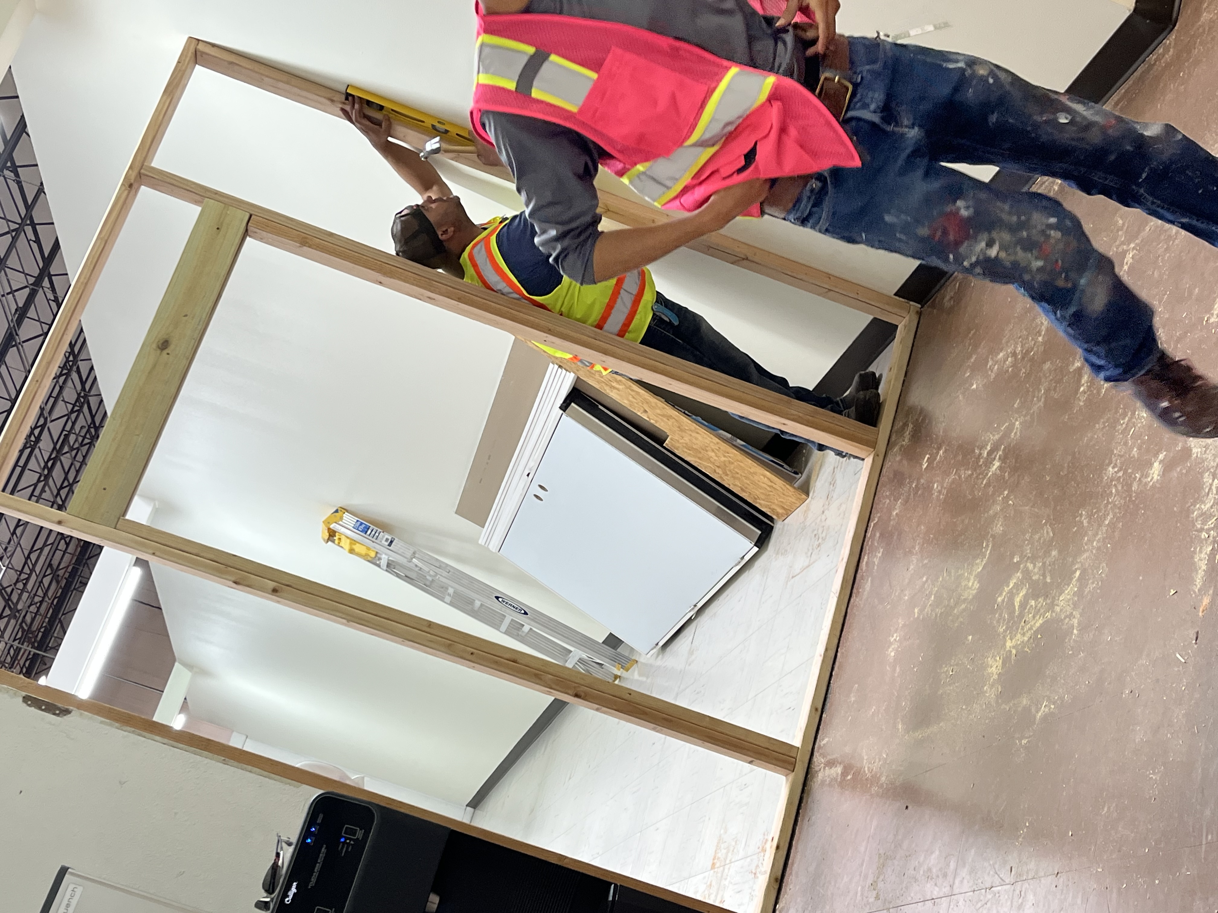 Crew framing interior walls and installing drywall on a commercial build-out